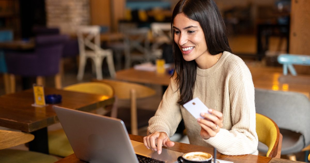 Consultar el registro civil por cédula: mujer con su documento frente al portátil
